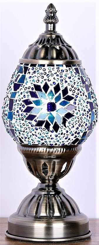 An oval mosaic lamp with blue, white, and black tiles, featuring a floral pattern, with a metal base.