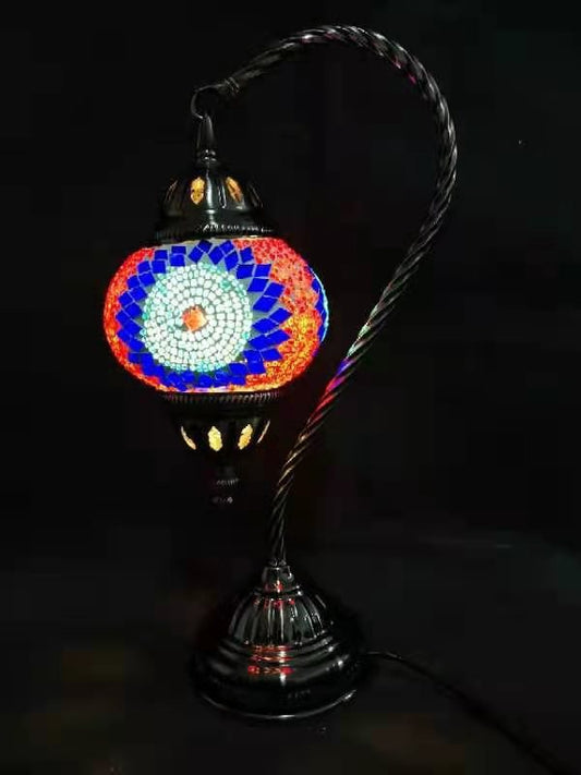 A multicolored Turkish mosaic lamp with a swan neck design, featuring a red base and a patterned glass shade.