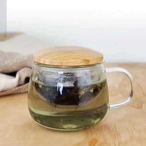 MagicT - Infuser Mug (Bamboo Lid) 300ml This infuser mug with a Bamboo wooden lid looks elegant, unique and handy. It is ideal to see the colour of your herbal tea. The mug is made of high borosilicate glass and the wooden lid allows to keep the heat and aroma of the tea inside the cup.