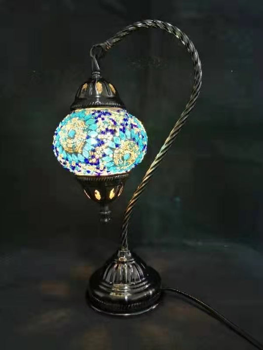 A Turkish mosaic lamp with a swan neck design featuring multicolored tiles, a black base, and a silver-colored handle.