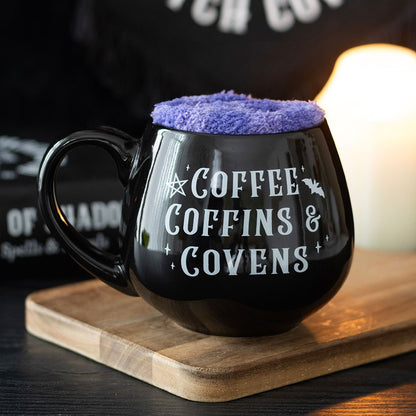 Coffee, Coffin &amp; Covens Mug And Socks Set&nbsp;
H:10.8 x W:14.3 x D:9.3 cm - Get comfy in true witchy style with this cauldron-shaped mug and fluffy socks gift set featuring the phrase 'Coffee, Coffins &amp; Covens'. The 450ml mug is perfect for a warming drink, while the soft purple socks add ultimate comfort for spell-casting Sundays or spooky movie nights. 450ml capacity. Microwave safe. Dishwasher safe.

SKU: SDCL43326