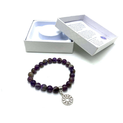 A purple amethyst crown chakra bracelet with a silver-colored fastener, displayed next to its open white box packaging.