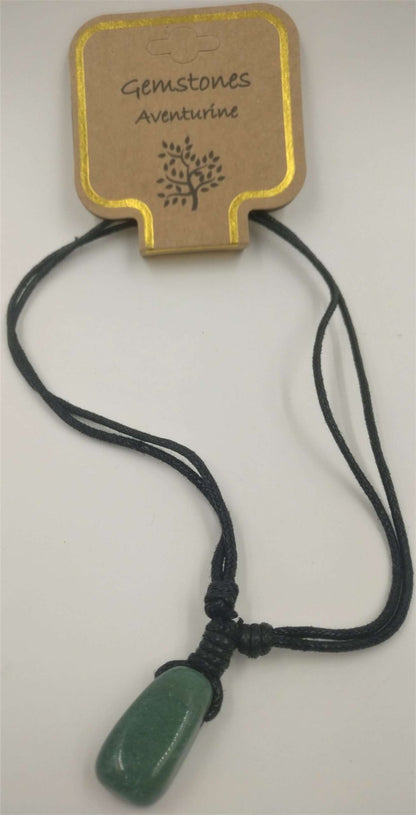 A green aventurine stone pendant attached to a beige card with the text 'GEMSTONES ADVENTURINE' and a decorative snowflake design at the top. A black cord connects the pendant to the card.