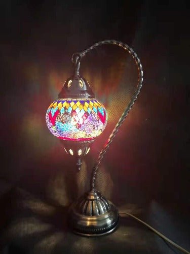 A multicolored Turkish mosaic lamp with a swan neck design, featuring a geometric pattern, mounted on a metal base with an LED light visible.